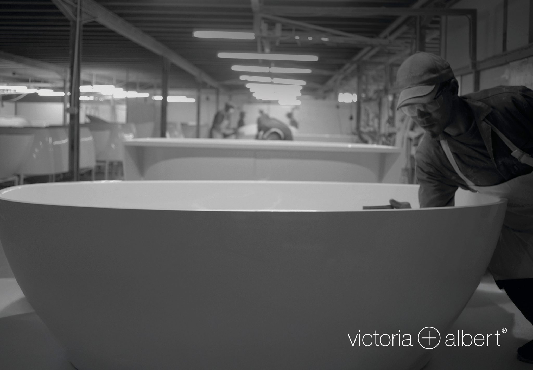 Artisan hand-finishing a freestanding bathtub in a workshop